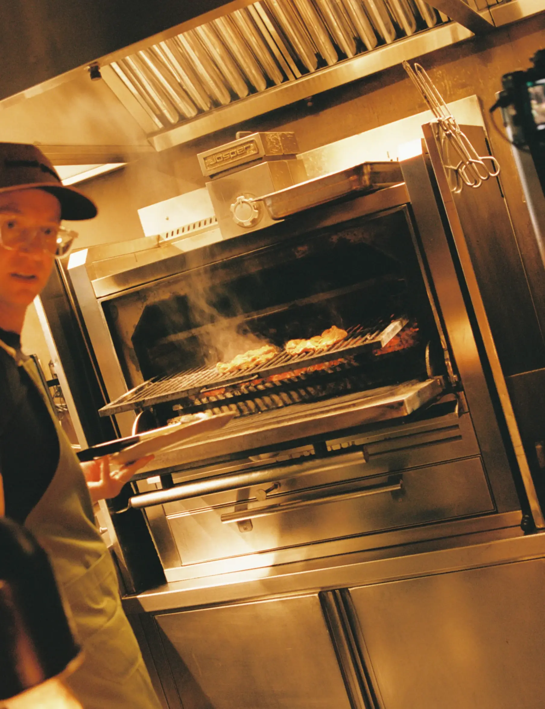 Honest Greens chef cooking over open fire in the Josper oven, showcasing our craft of cooking.